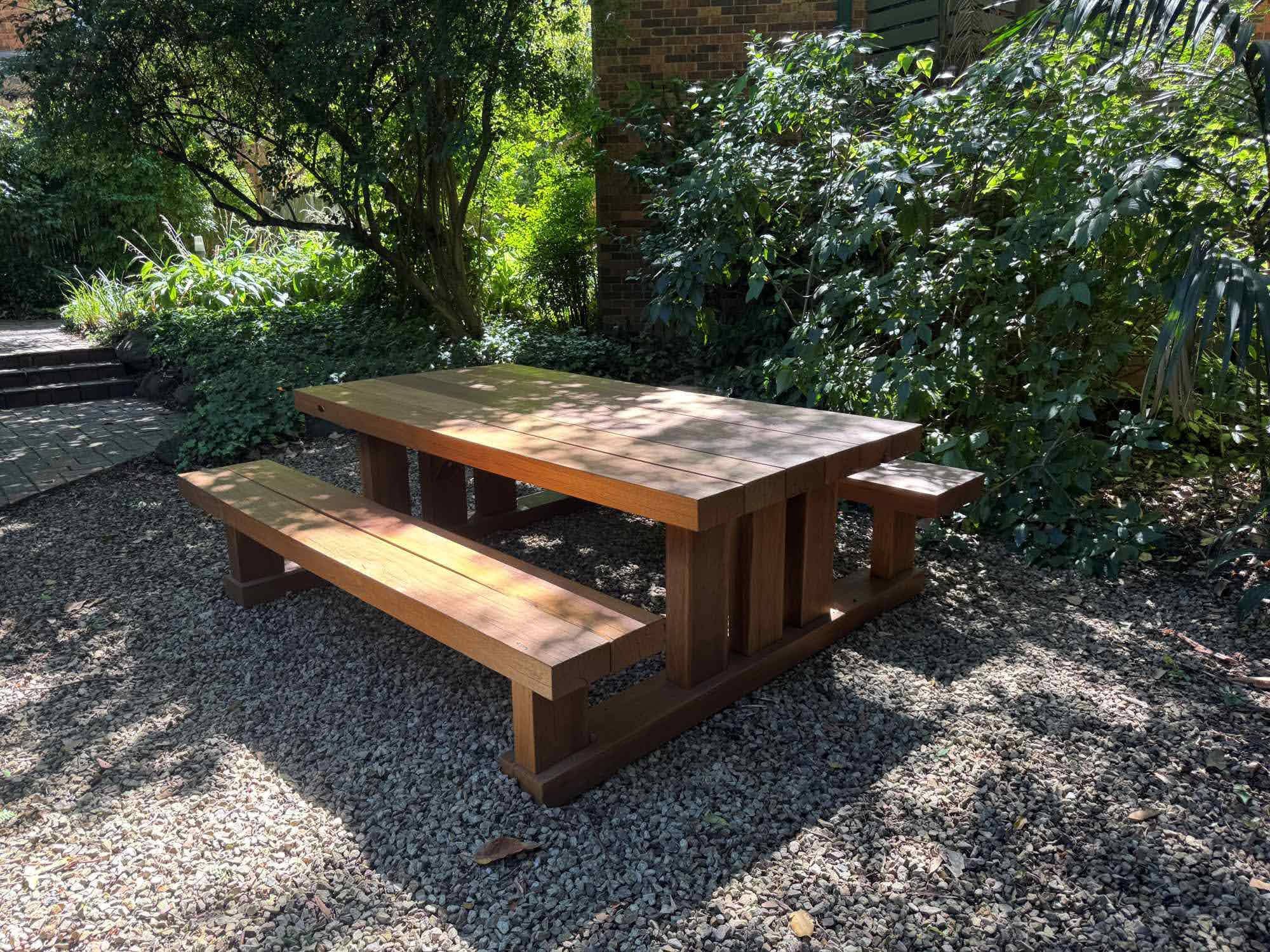 Handcrafted Australian hardwood picnic table and bench setting in a shaded garden